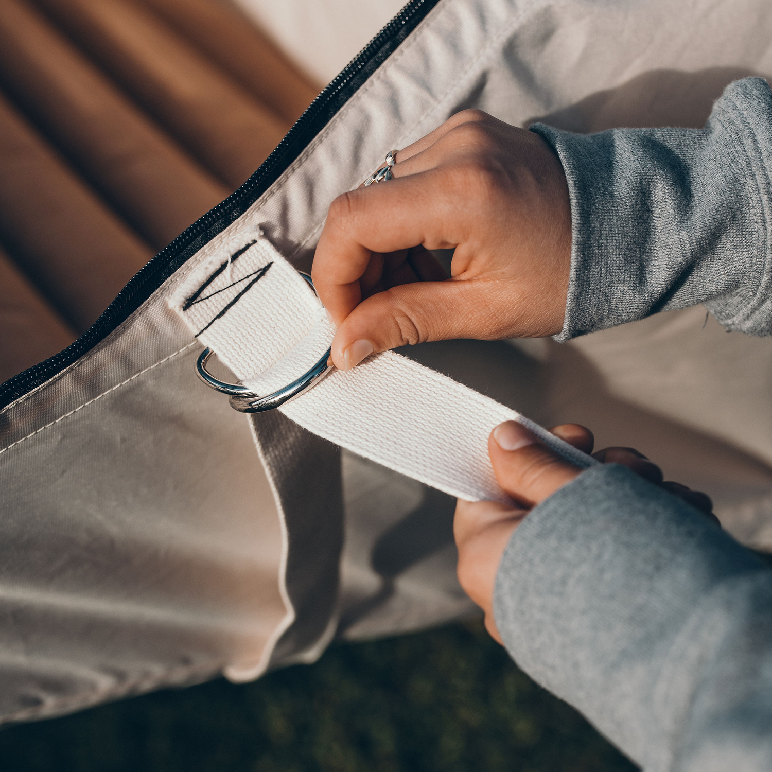 Two hands setting up a flat lay hammock tent