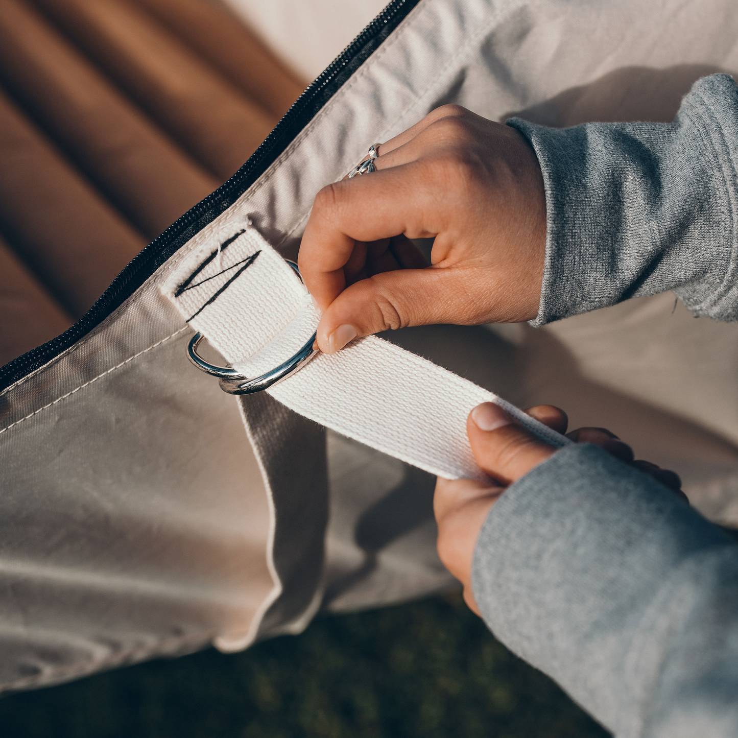 Two hands setting up a flat lay hammock tent