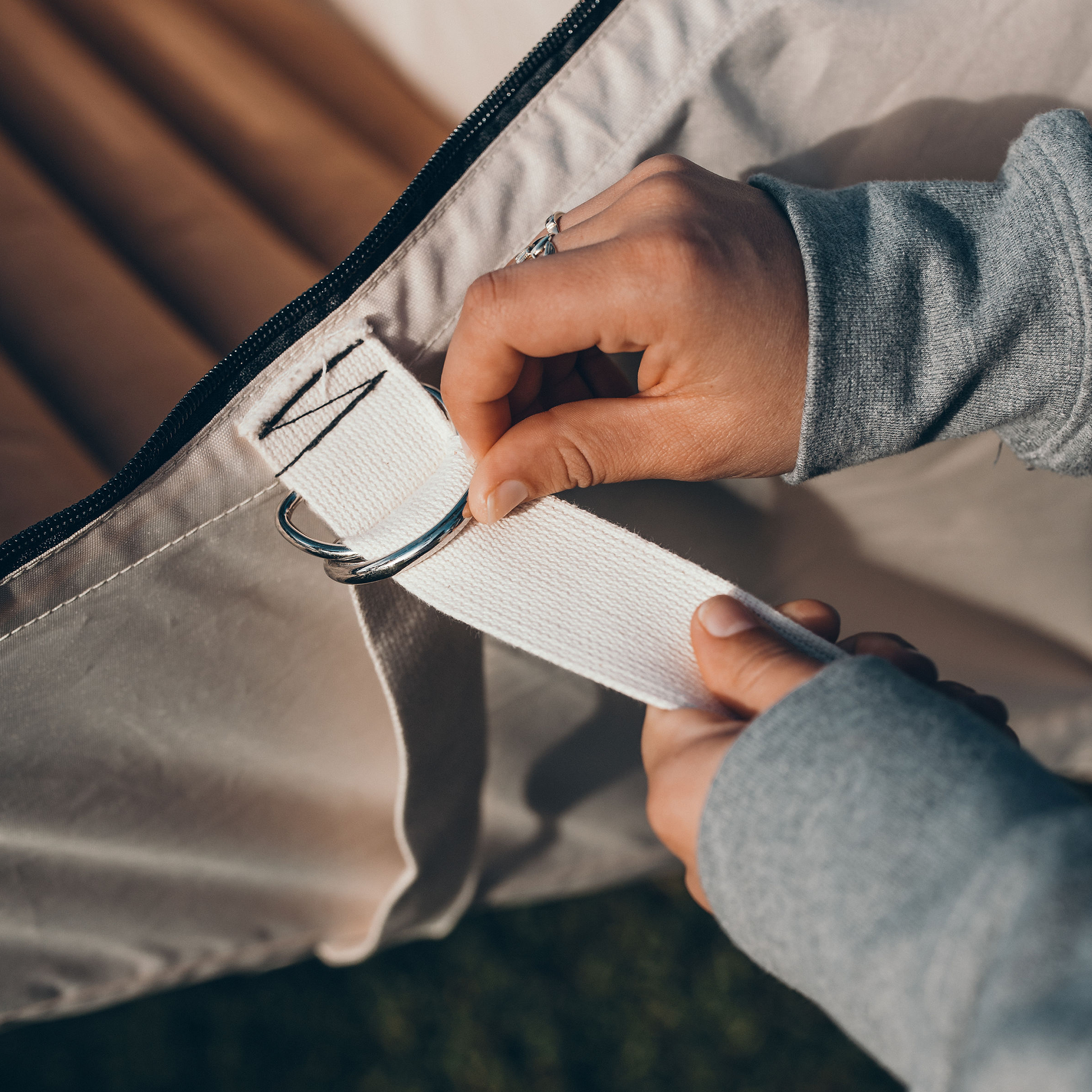Two hands setting up a flat lay hammock tent