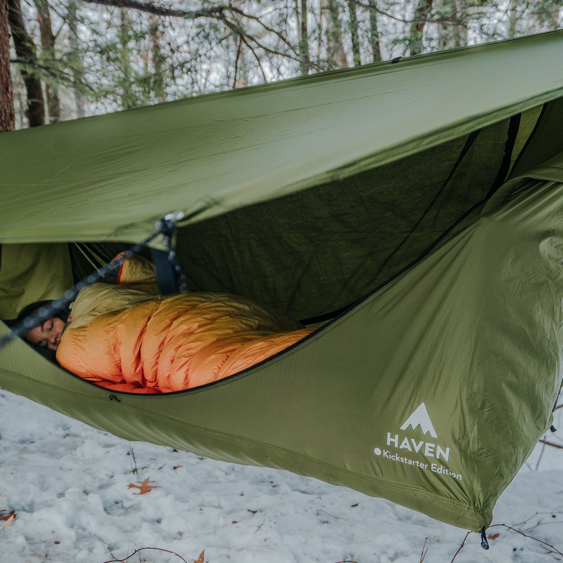 Woman sleeping in a hammock tent outdoors in winter