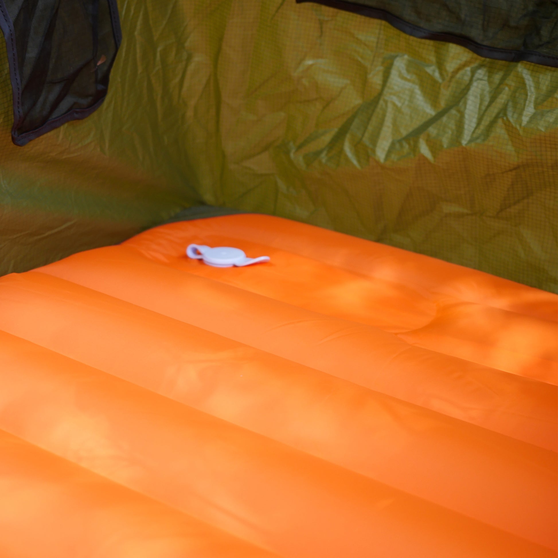 Orange ultralight sleeping pad inside camping hammock