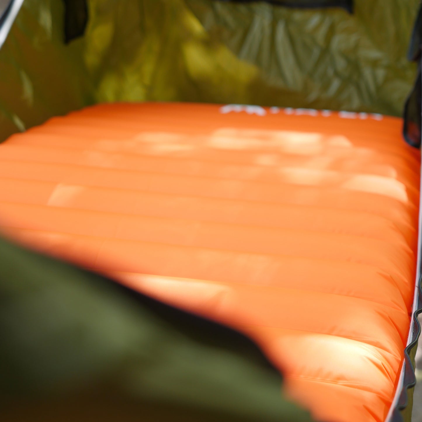 Orange lightweight sleeping pad inside portable camping hammock