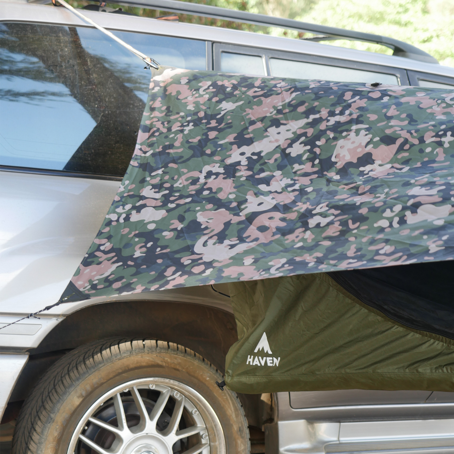 Camouflage hammock tent hanging from a car roof rack